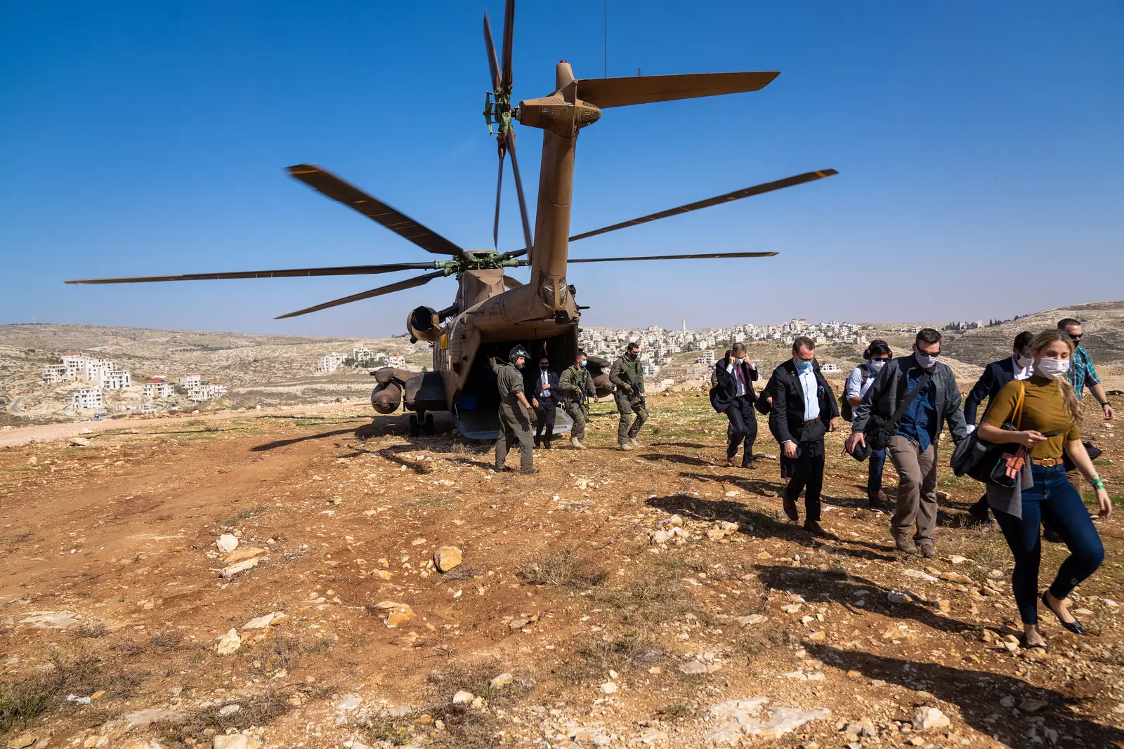 פמליית מזכיר המדינה פומפאו ליד מסוק בגבעות פסגות